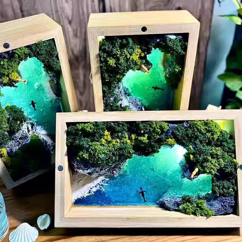 Three wooden picture frames displaying an aerial view of a tropical cove with clear blue water and greenery.